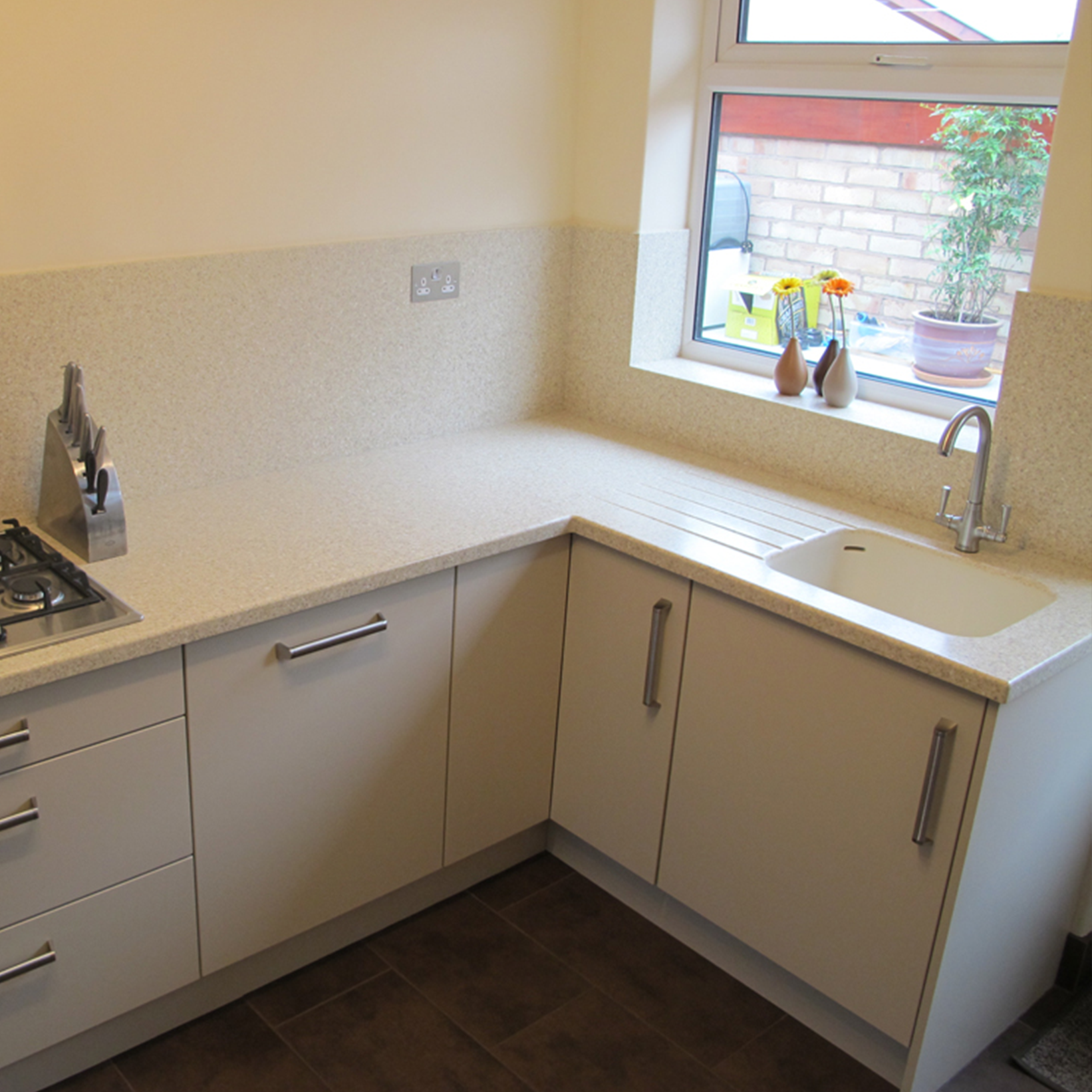 Solid surface splashback behind a hob